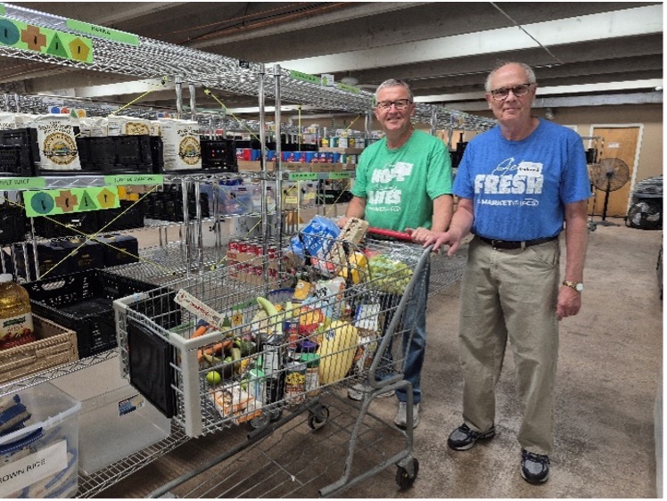 Photo of Kevin and another volunteer in the IFCS Market